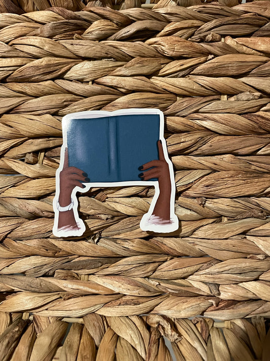 Dark skin hands with book sticker